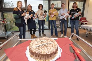 Mehrere Personen stehen um eine Torte herum