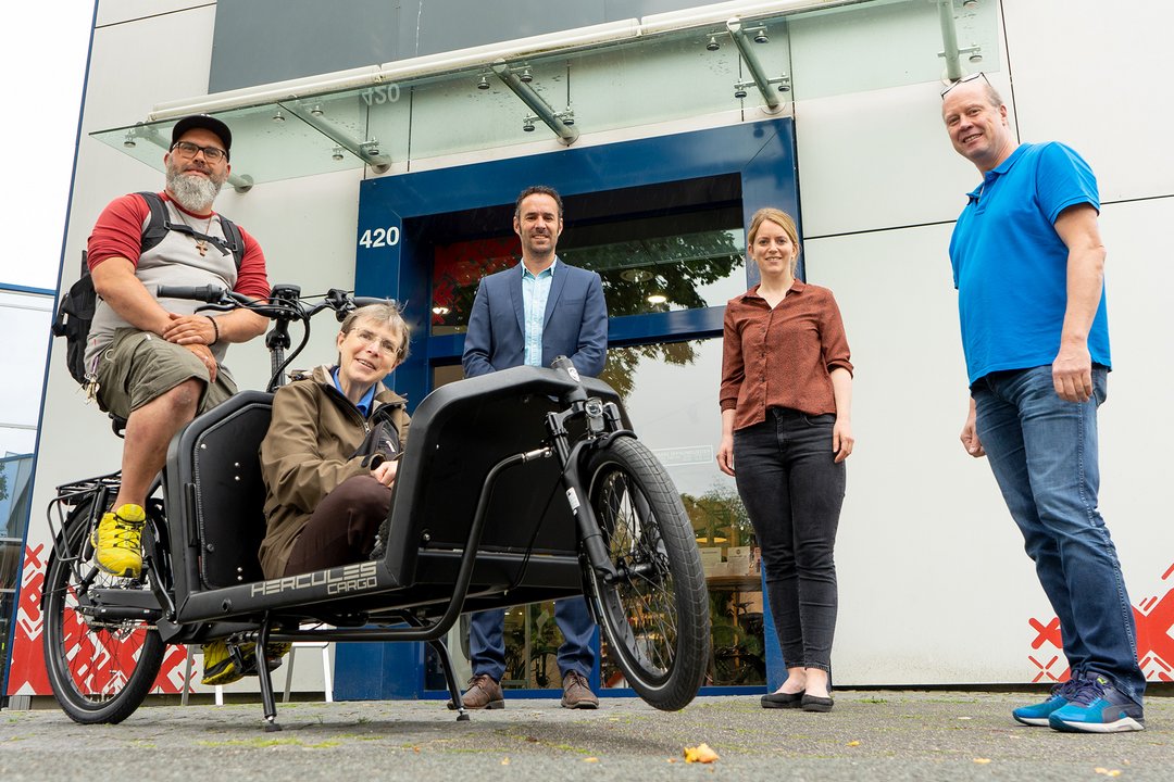 Mehrere Menschen stehen um ein Lastenrad herum