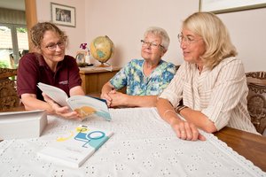 Eine Mitarbeiterin der Familialen Pflege im Gespräch mit Angehörigen